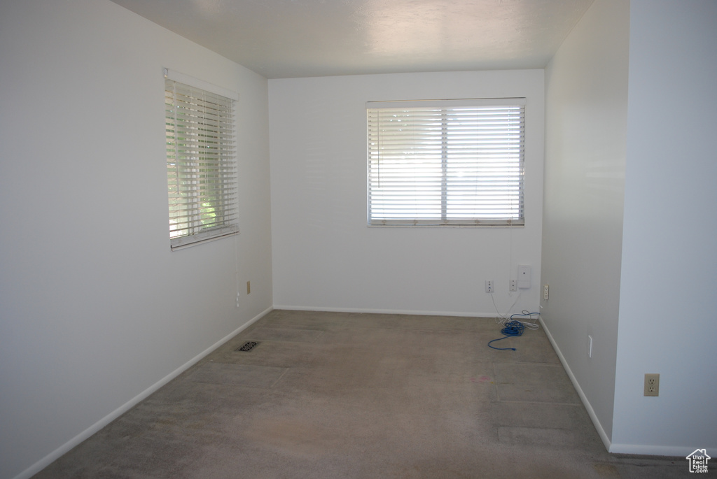Empty room featuring carpet floors and baseboards