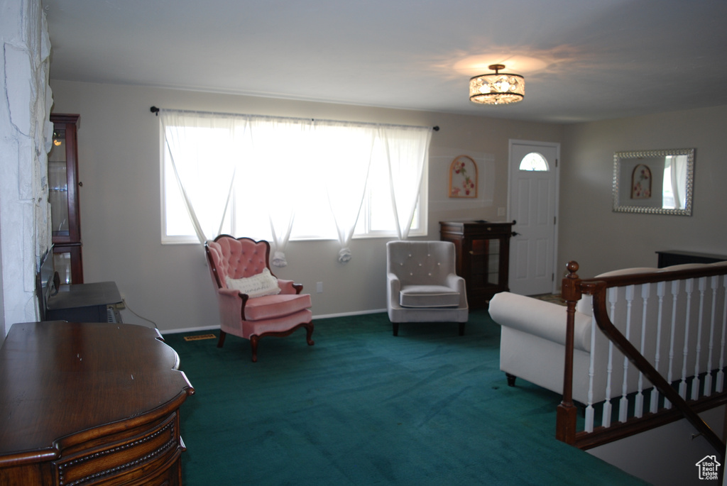 Sitting room with an upstairs landing, carpet, a chandelier, and baseboards