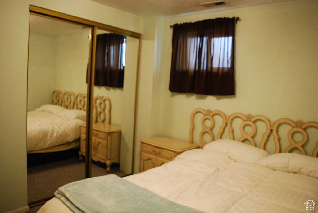 Bedroom featuring visible vents, carpet, and a closet