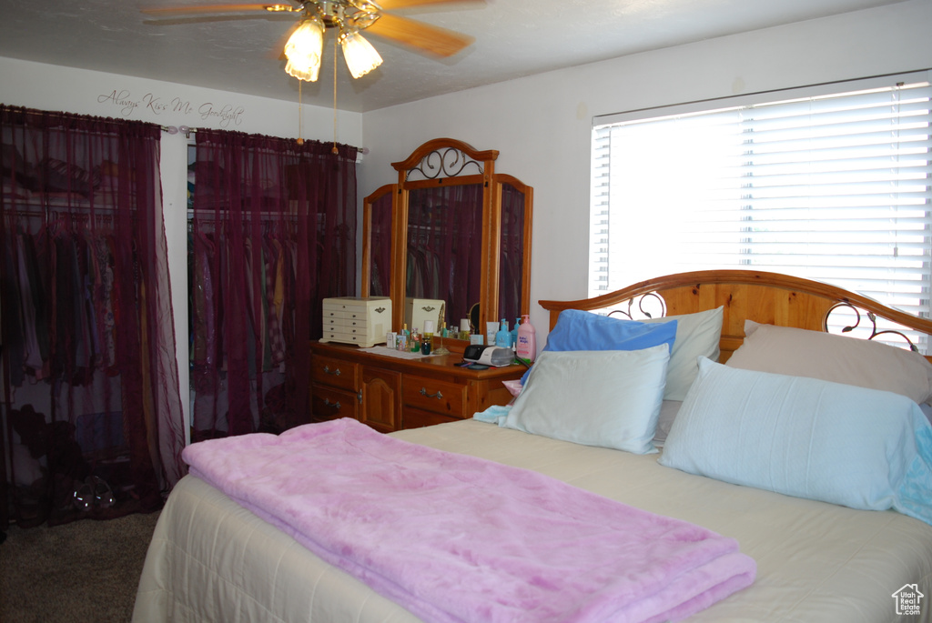 Carpeted bedroom with a ceiling fan