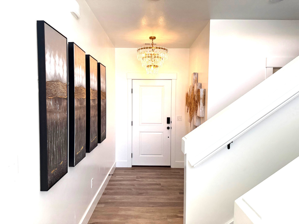 Corridor featuring stairs, an inviting chandelier, wood finished floors, and baseboards