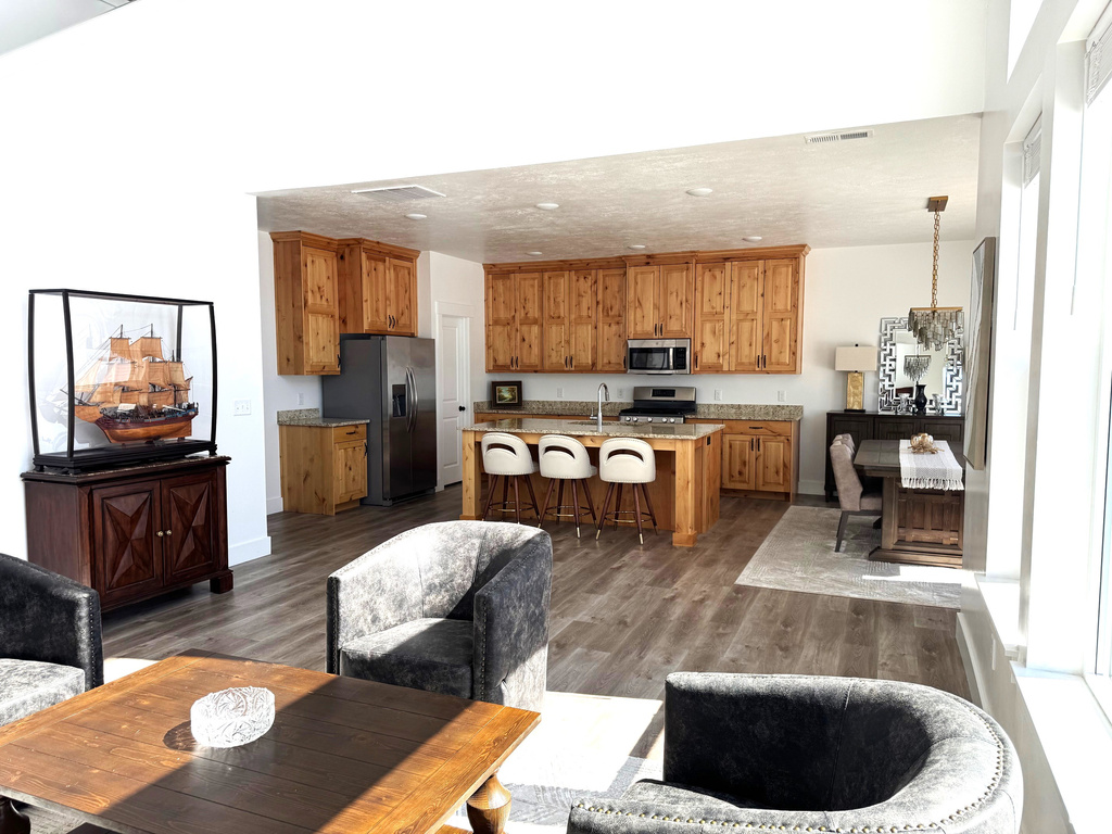 Living room with visible vents, baseboards, and wood finished floors