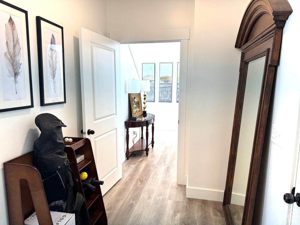 Hallway with baseboards and light wood-style floors