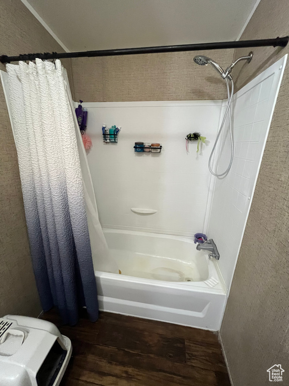 Bathroom featuring wood finished floors and shower / tub combo with curtain