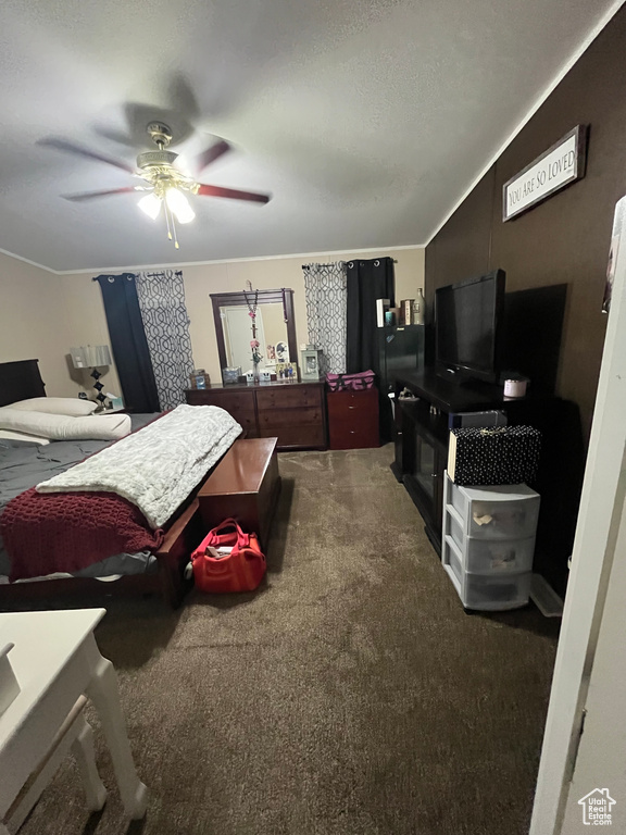 Carpeted bedroom featuring a textured ceiling and ceiling fan