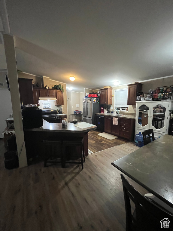 Kitchen with a sink, stainless steel appliances, dark wood-type flooring, and dark brown cabinetry
