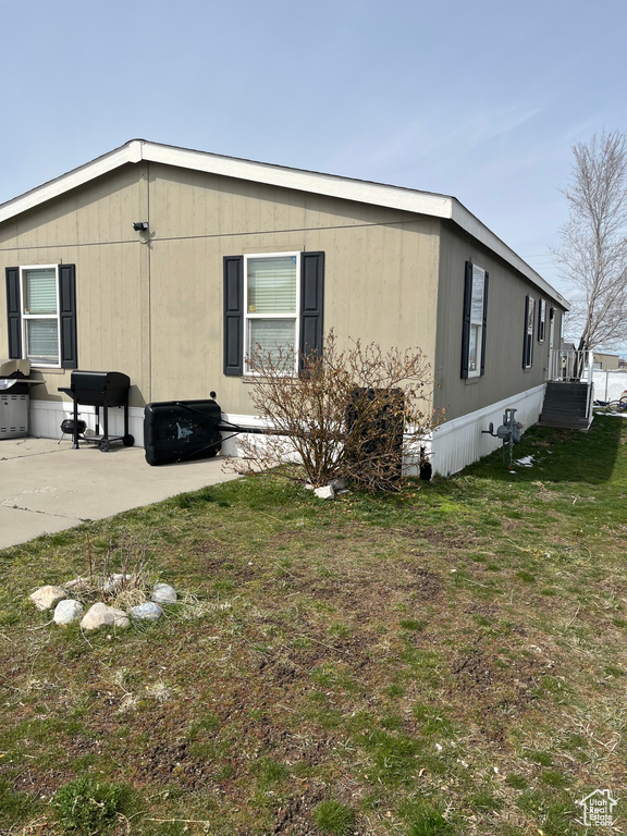View of home\\\'s exterior featuring a lawn and a patio area