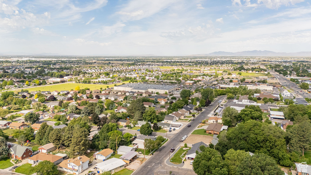 Aerial view of property and surrounding area with a mountainous background and nearby suburban area