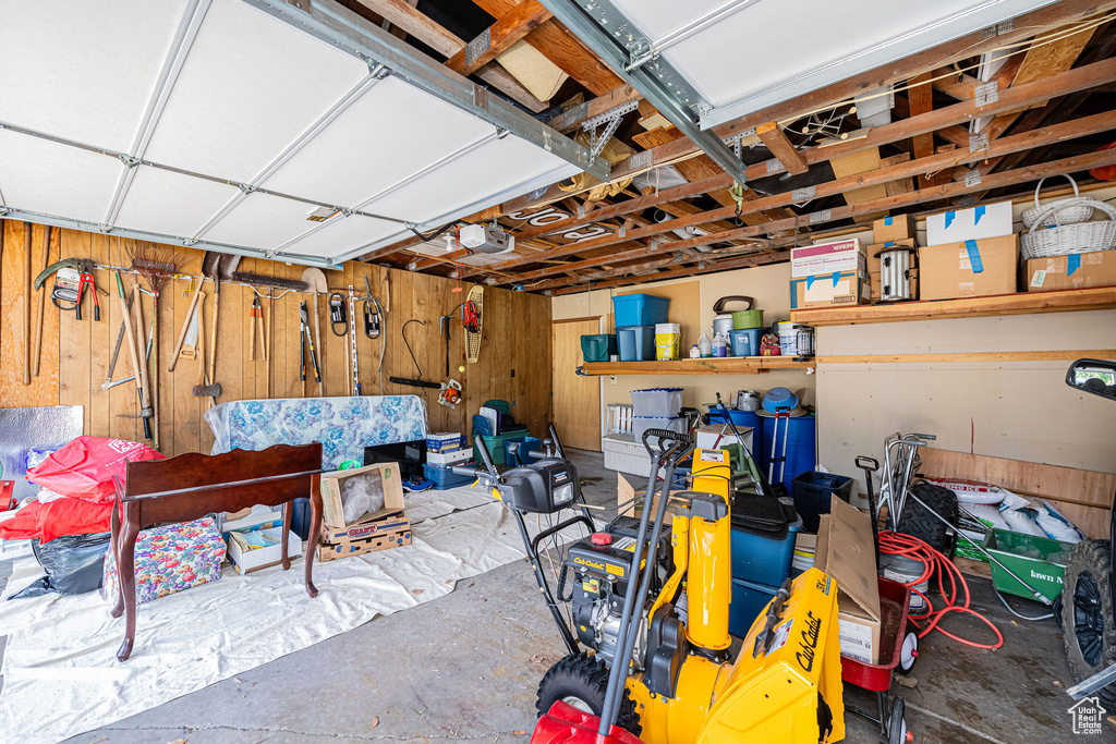 Garage featuring wooden walls and a garage door opener