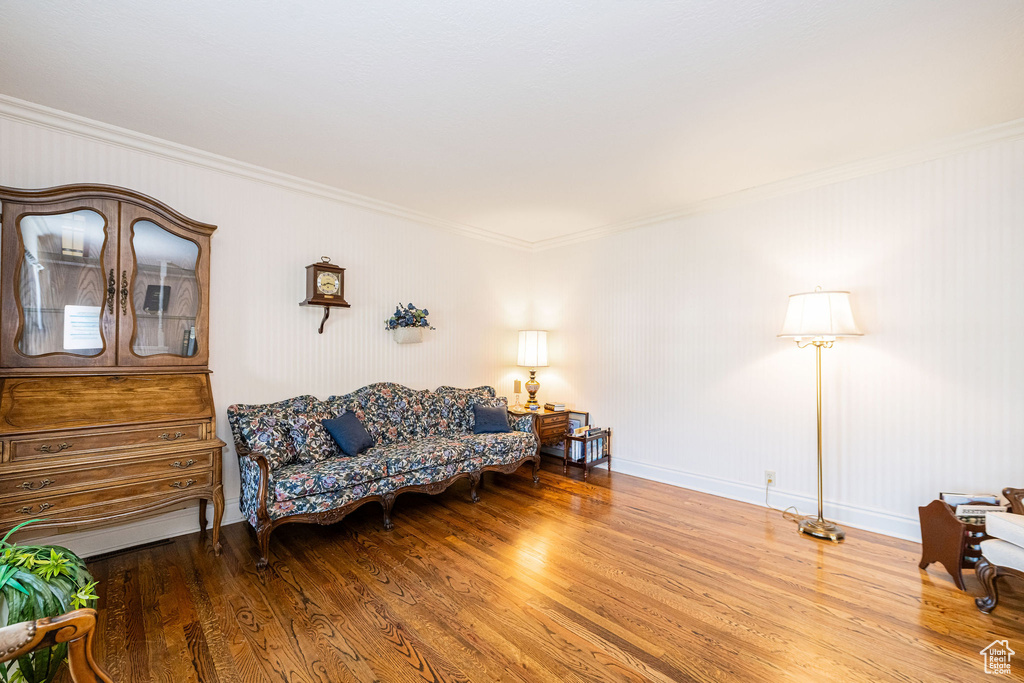 Living room featuring crown molding, wood finished floors, and baseboards