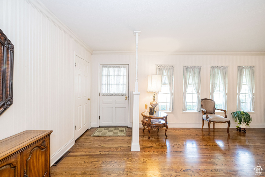 Entrance foyer featuring crown molding, light wood-type flooring, and baseboards