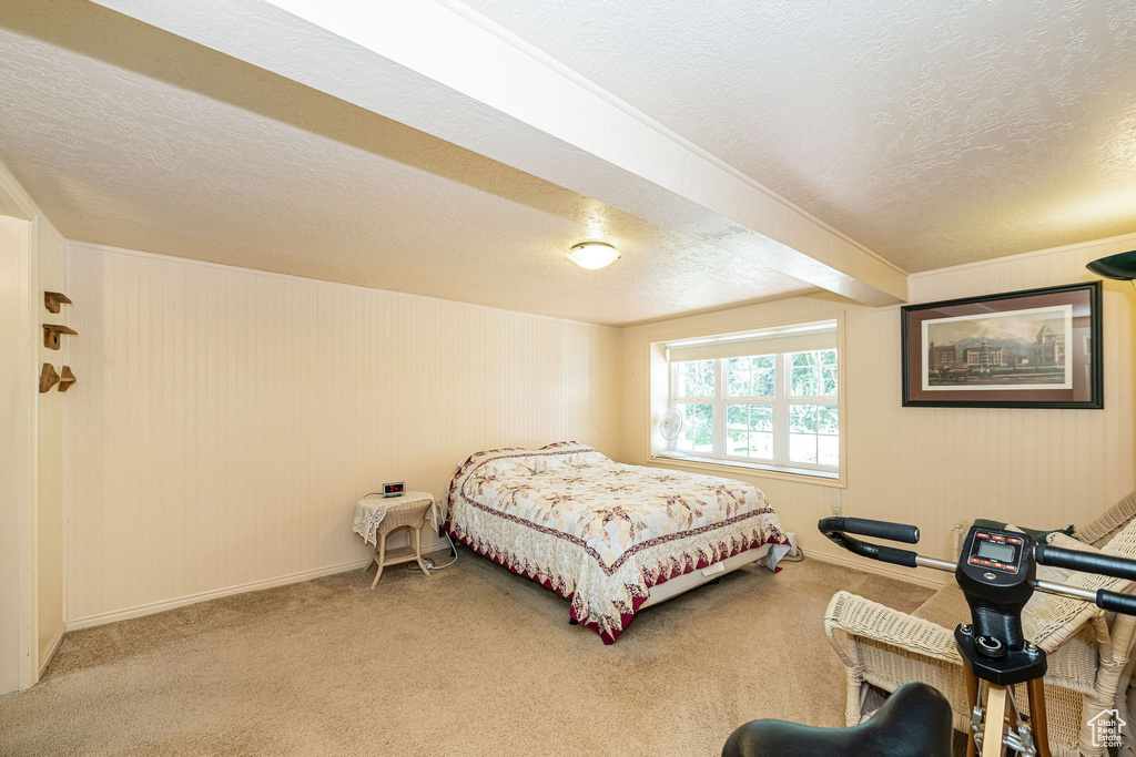Carpeted bedroom featuring a textured ceiling and baseboards