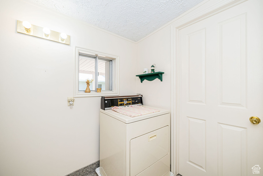 Laundry room featuring washer / dryer and a textured ceiling