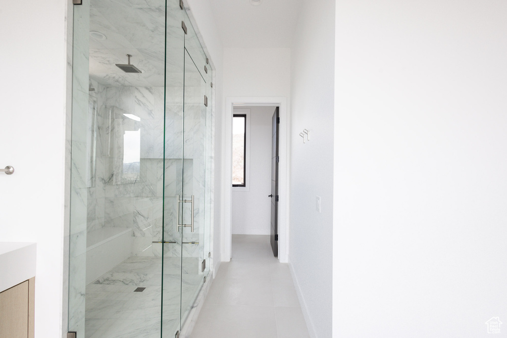 Full bathroom featuring a marble finish shower, baseboards, and vanity