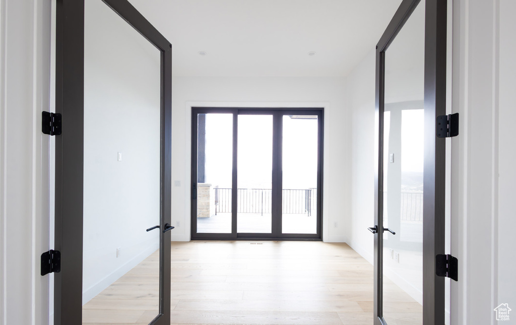 Hallway featuring french doors and light wood-type flooring