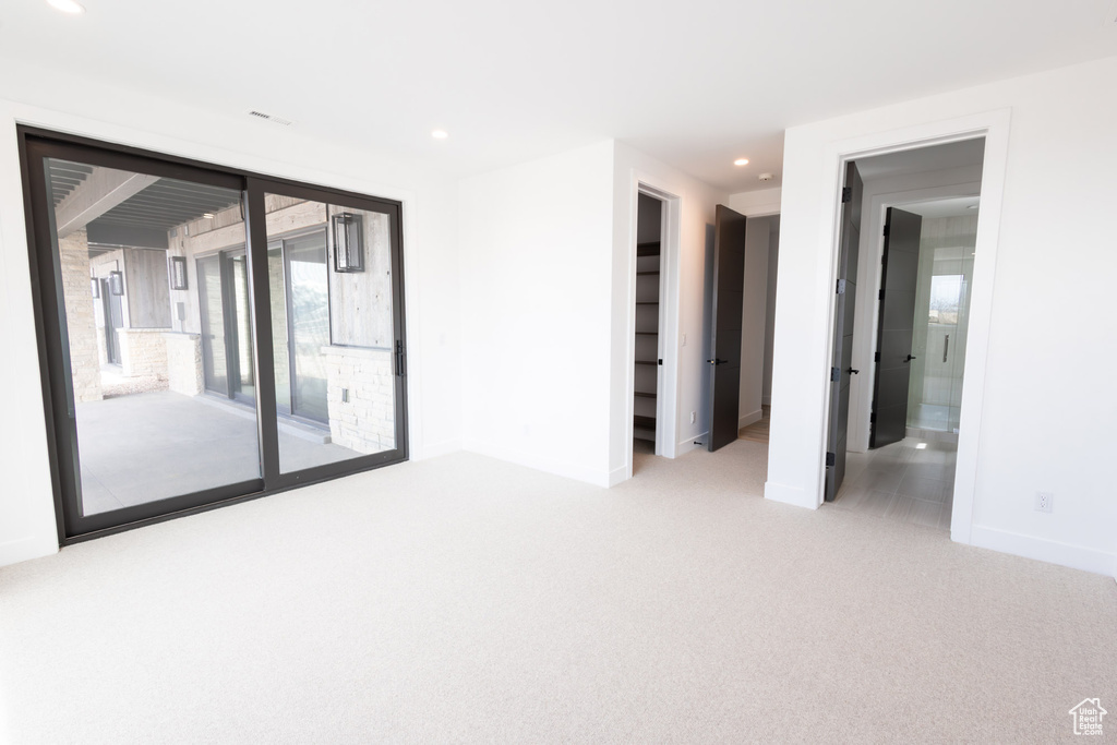 Carpeted empty room featuring recessed lighting and baseboards
