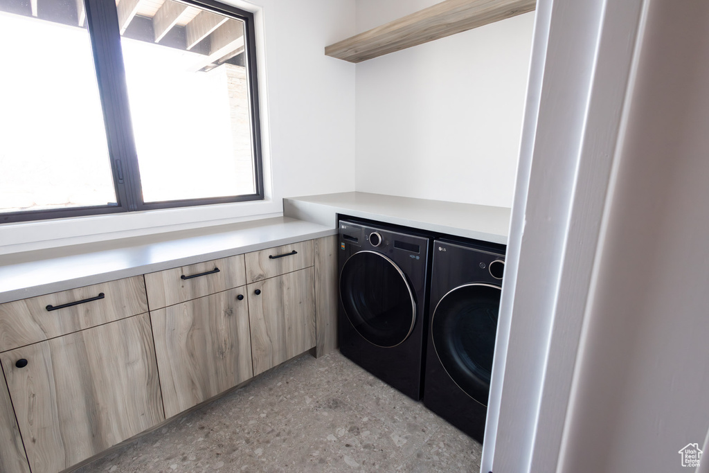 Washroom featuring independent washer and dryer and cabinet space