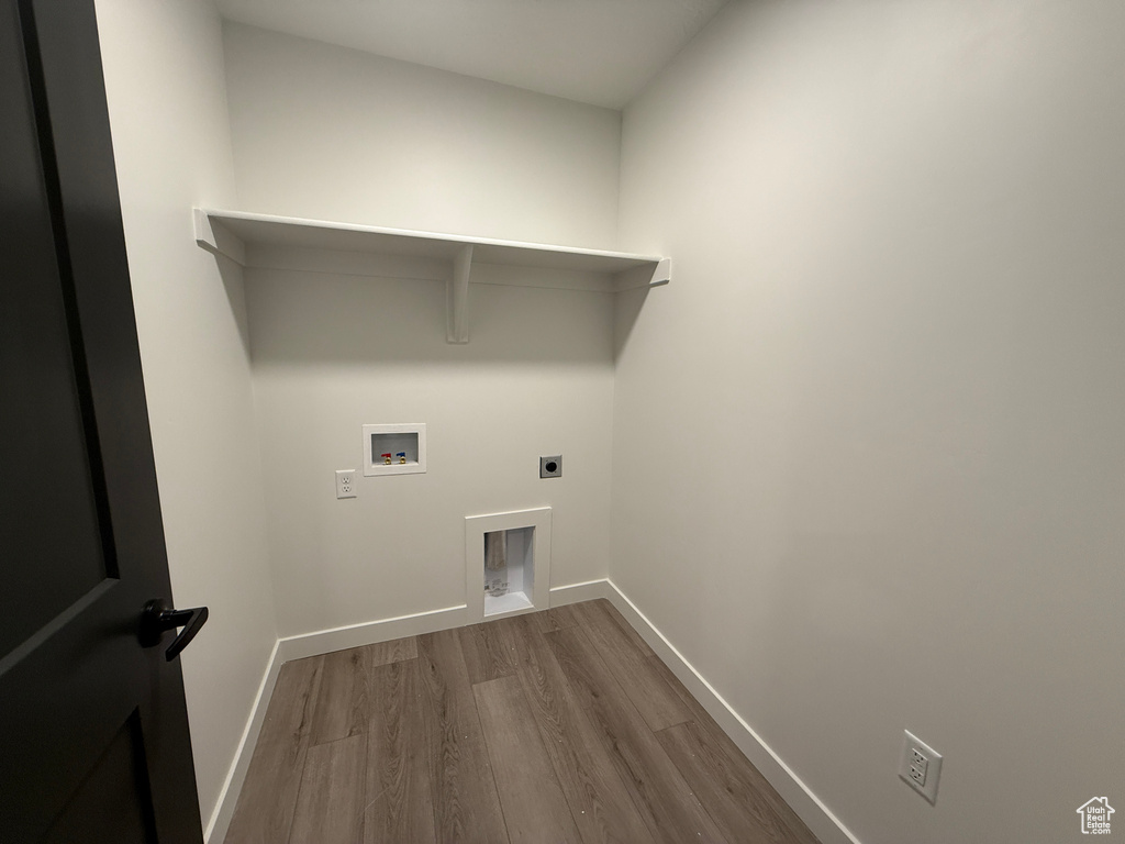 Laundry room featuring dark wood finished floors, laundry area, baseboards, and electric dryer hookup
