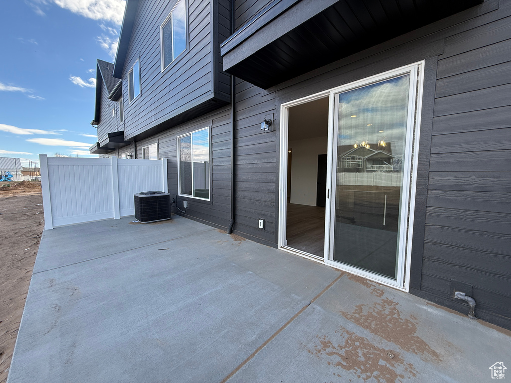View of patio featuring central air condition unit and fence