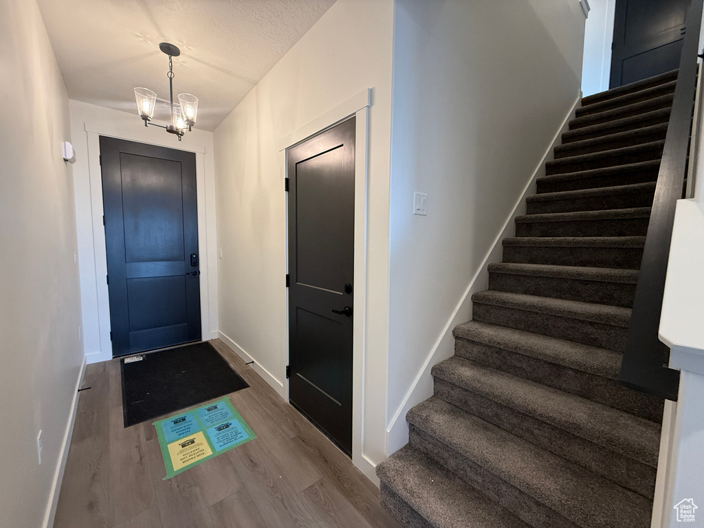 Entryway featuring stairs, baseboards, and wood finished floors