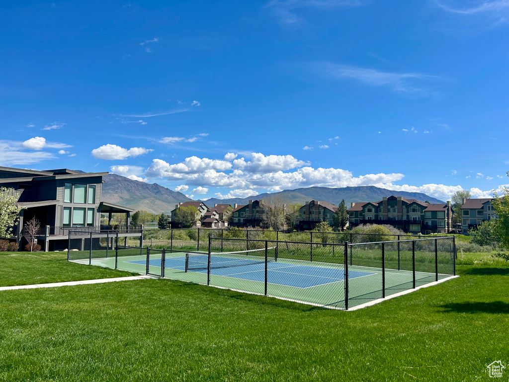 View of tennis court with a mountain view and a residential view