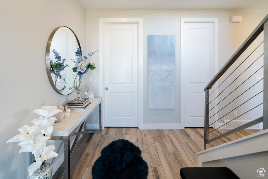 Foyer entrance with stairway and light wood-style floors