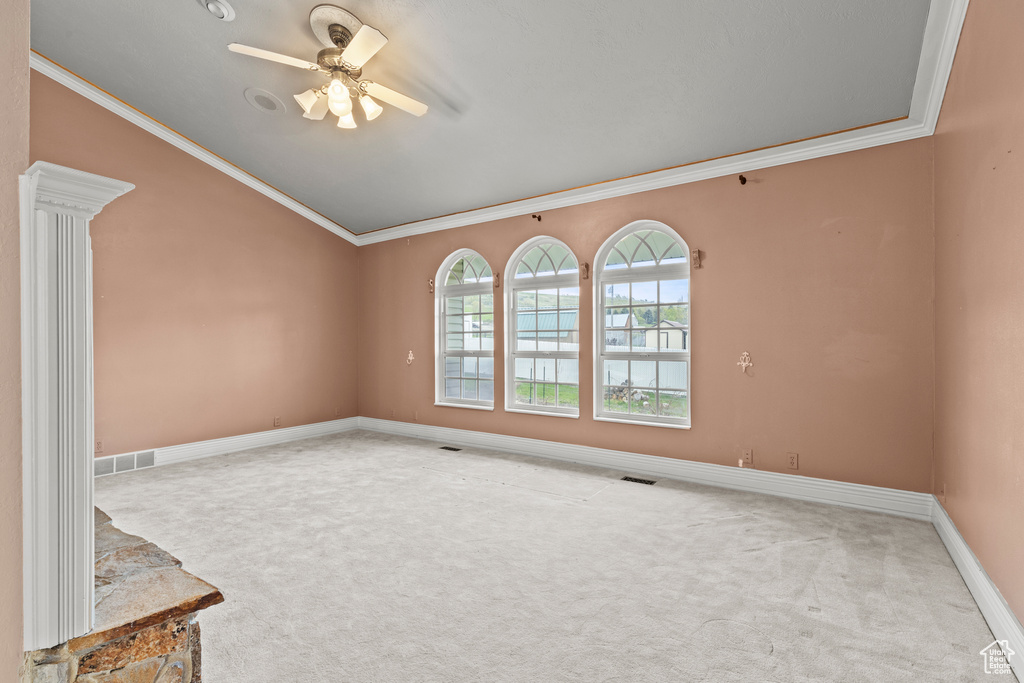 Empty room featuring crown molding, carpet floors, and visible vents
