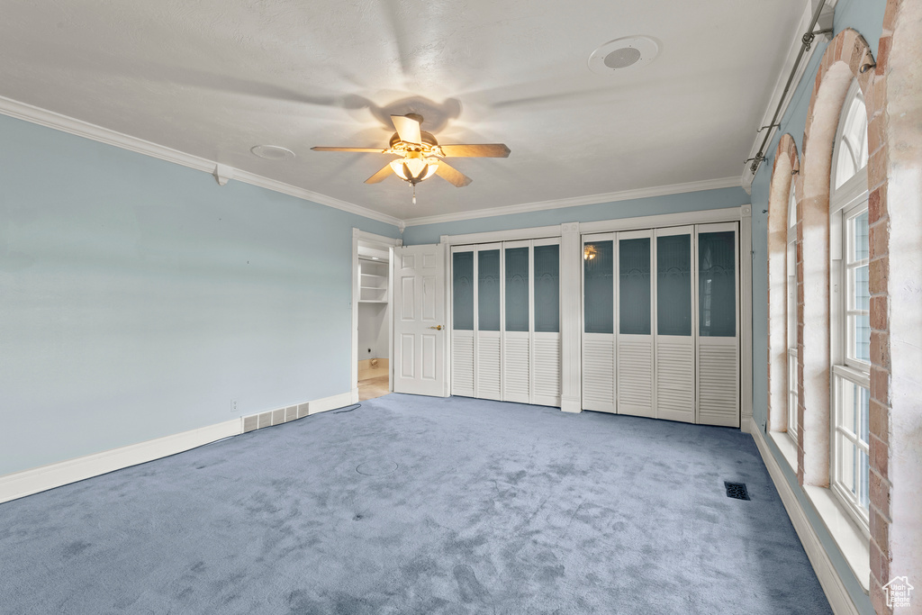 Spare room with visible vents, a ceiling fan, a healthy amount of sunlight, and ornamental molding