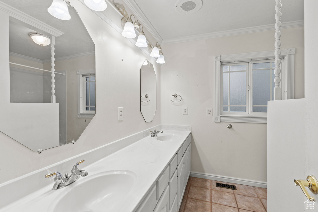Bathroom featuring crown molding, baseboards, and a sink