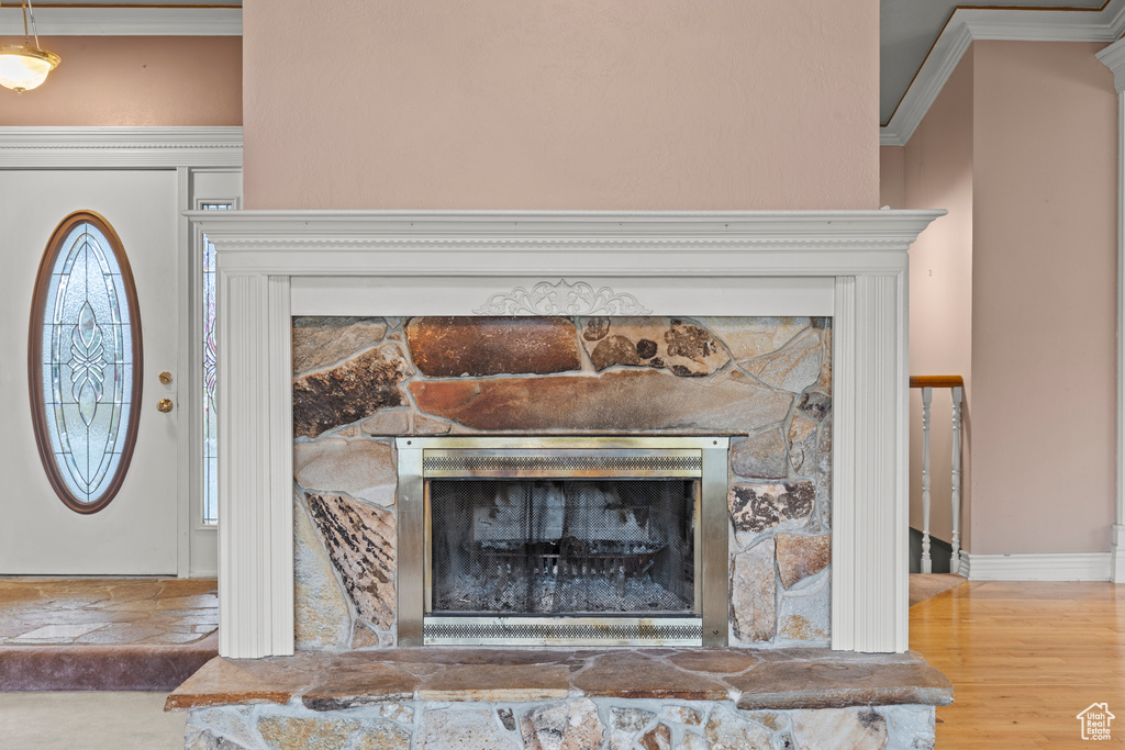 Room details with crown molding and a stone fireplace
