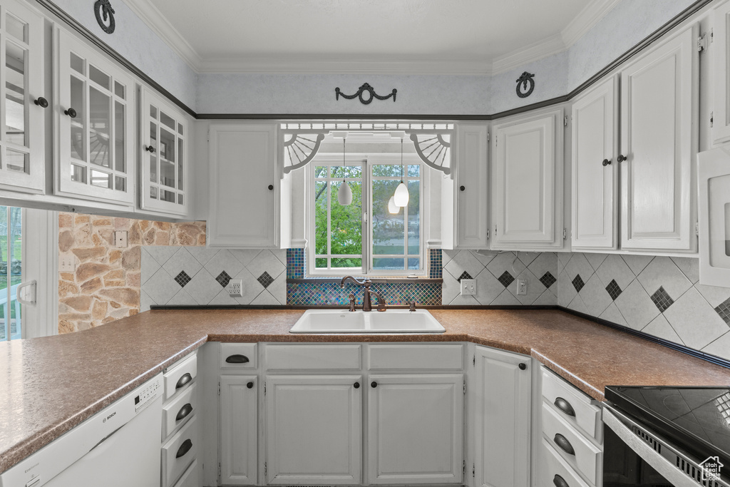 Kitchen with a sink, dishwasher, white cabinets, and glass insert cabinets