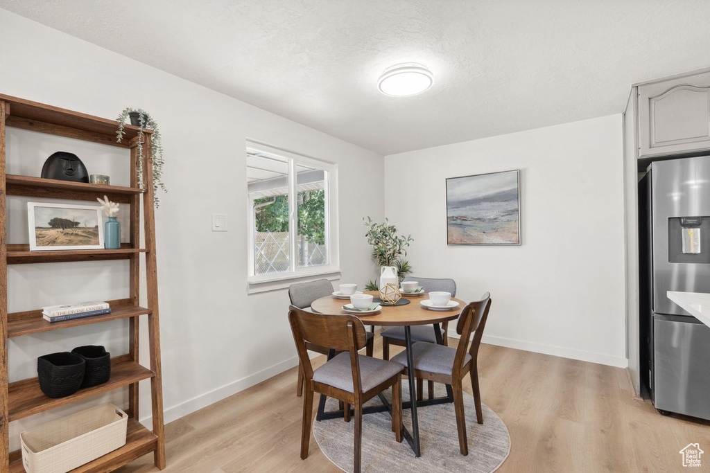 Dining area with light wood-style floors and baseboards