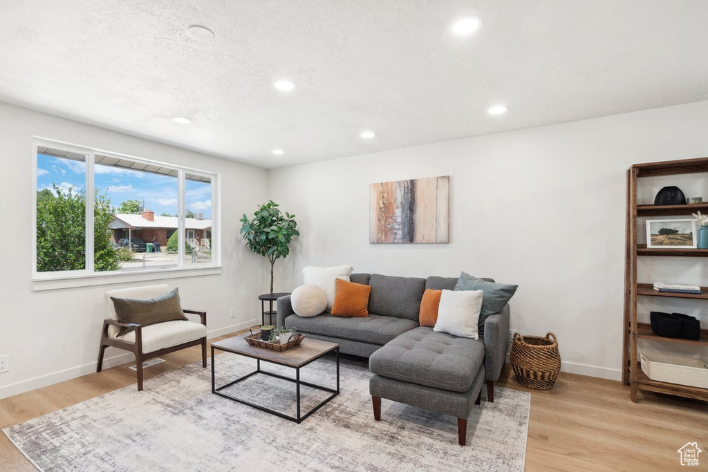Living area with recessed lighting, baseboards, and light wood-type flooring