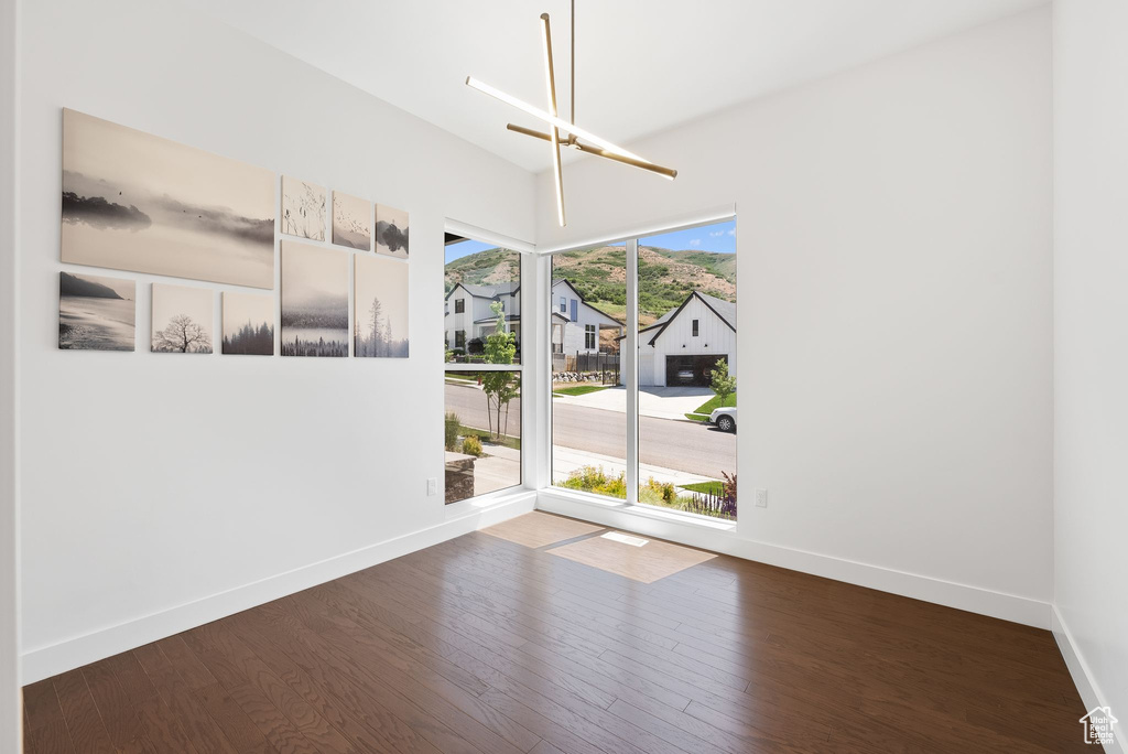 Unfurnished room with wood finished floors, baseboards, and a residential view