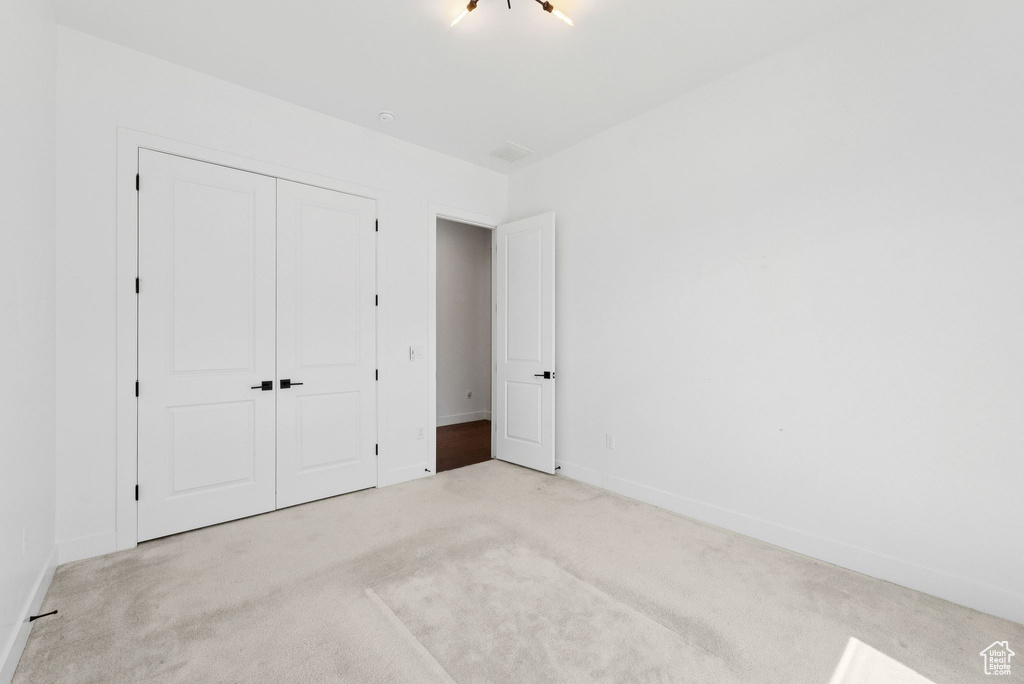 Unfurnished bedroom featuring carpet flooring, a closet, and baseboards