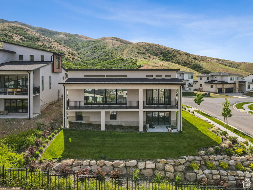 Rear view of property featuring a balcony, a mountain view, and stucco siding