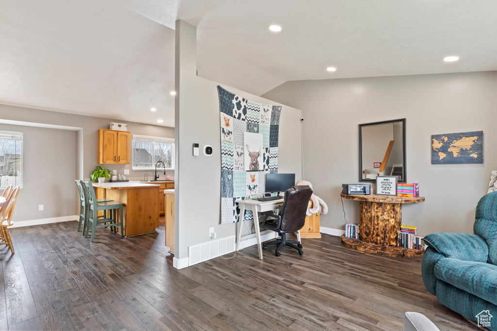 Office space featuring baseboards, lofted ceiling, dark wood-style floors, and plenty of natural light
