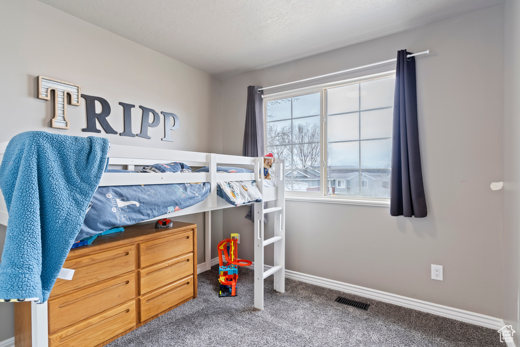 Carpeted bedroom with baseboards and visible vents