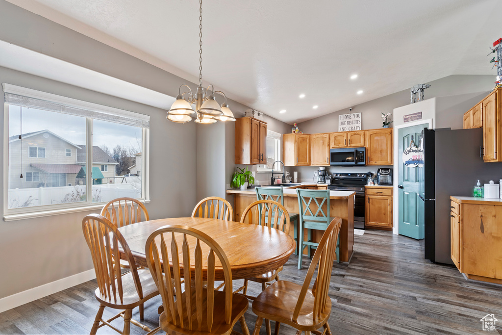 Dining space with vaulted ceiling, a chandelier, dark wood finished floors, baseboards, and recessed lighting