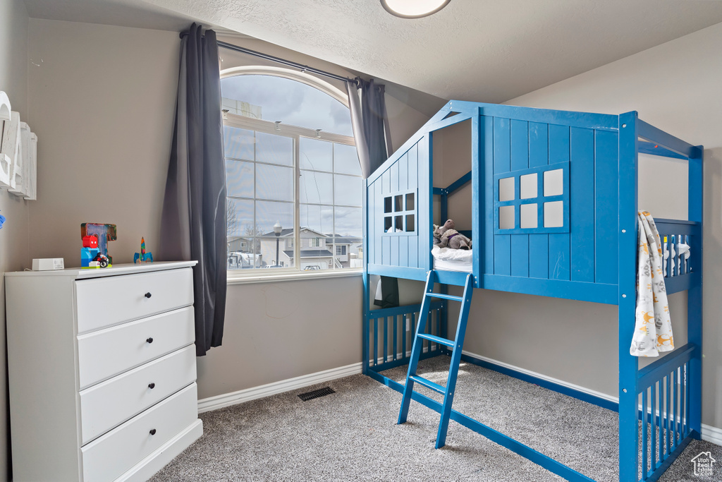 Bedroom with baseboards, visible vents, carpet flooring, and a textured ceiling