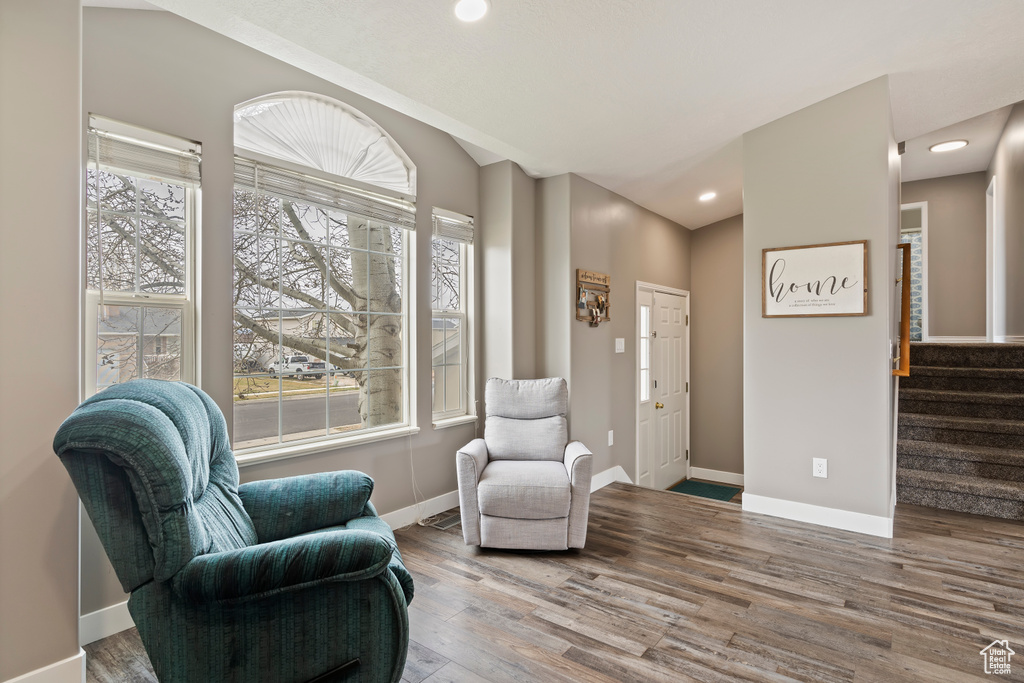 Sitting room featuring plenty of natural light, baseboards, stairs, and wood finished floors