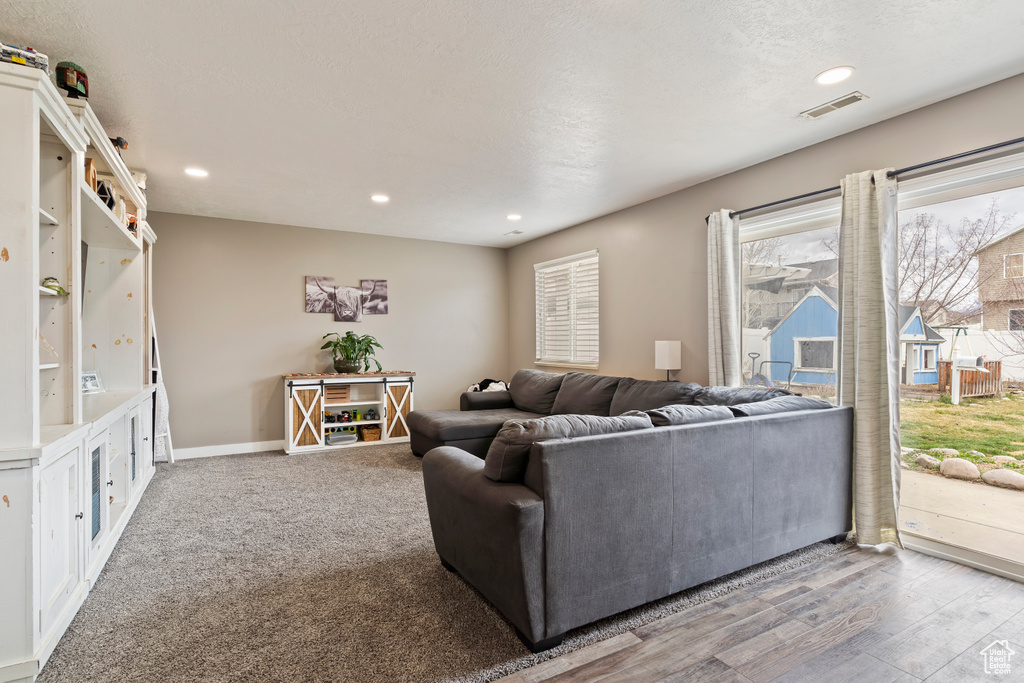 Living area with baseboards, visible vents, recessed lighting, and a textured ceiling