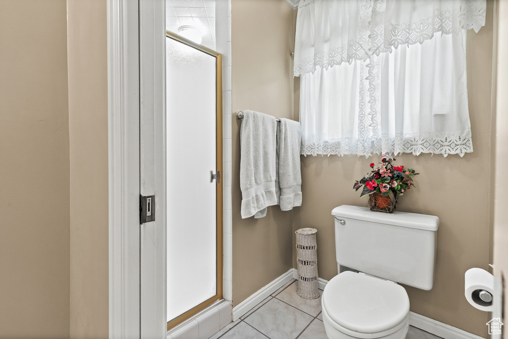 Full bath featuring a shower stall and tile patterned floors