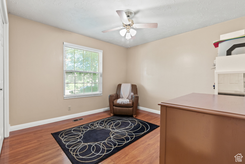 Sitting room with wood finished floors and ceiling fan