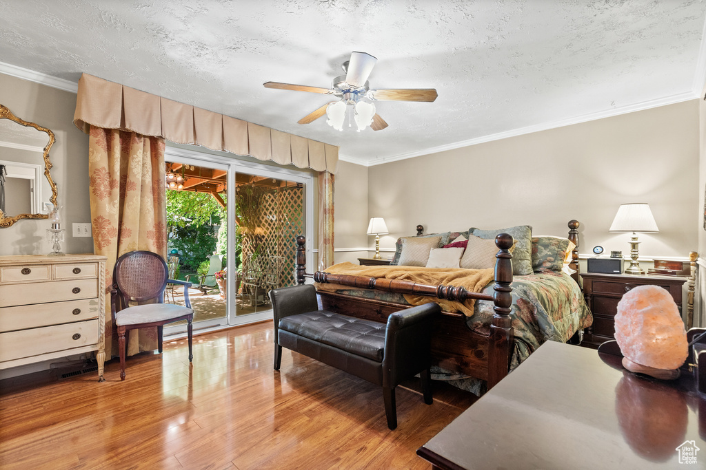 Bedroom featuring access to outside, light wood-style flooring, ornamental molding, a textured ceiling, and ceiling fan