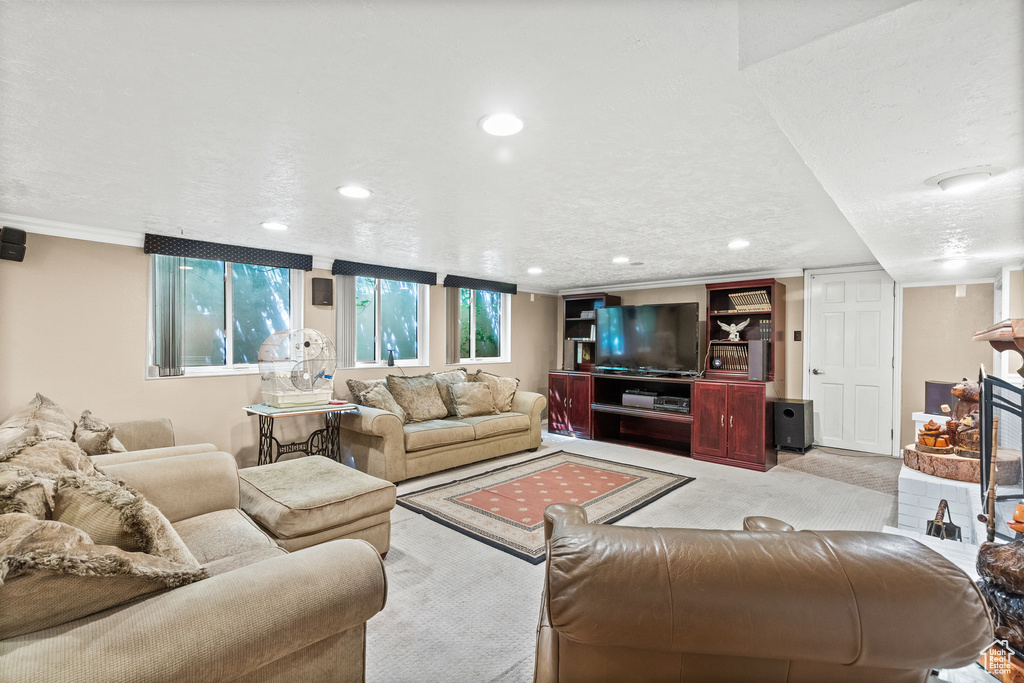 Living room with ornamental molding, recessed lighting, and light carpet