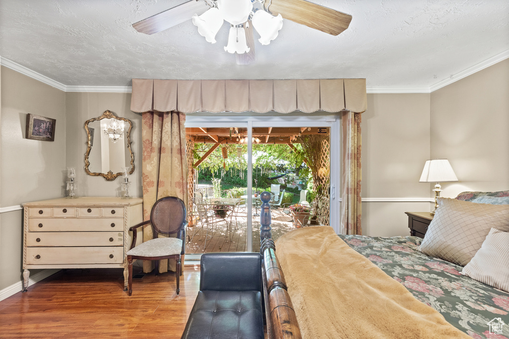 Bedroom with wood finished floors, crown molding, access to exterior, and a ceiling fan