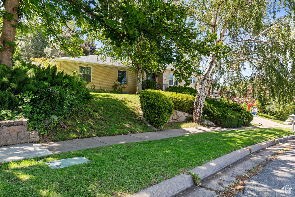 View of front of home featuring brick siding and a front yard