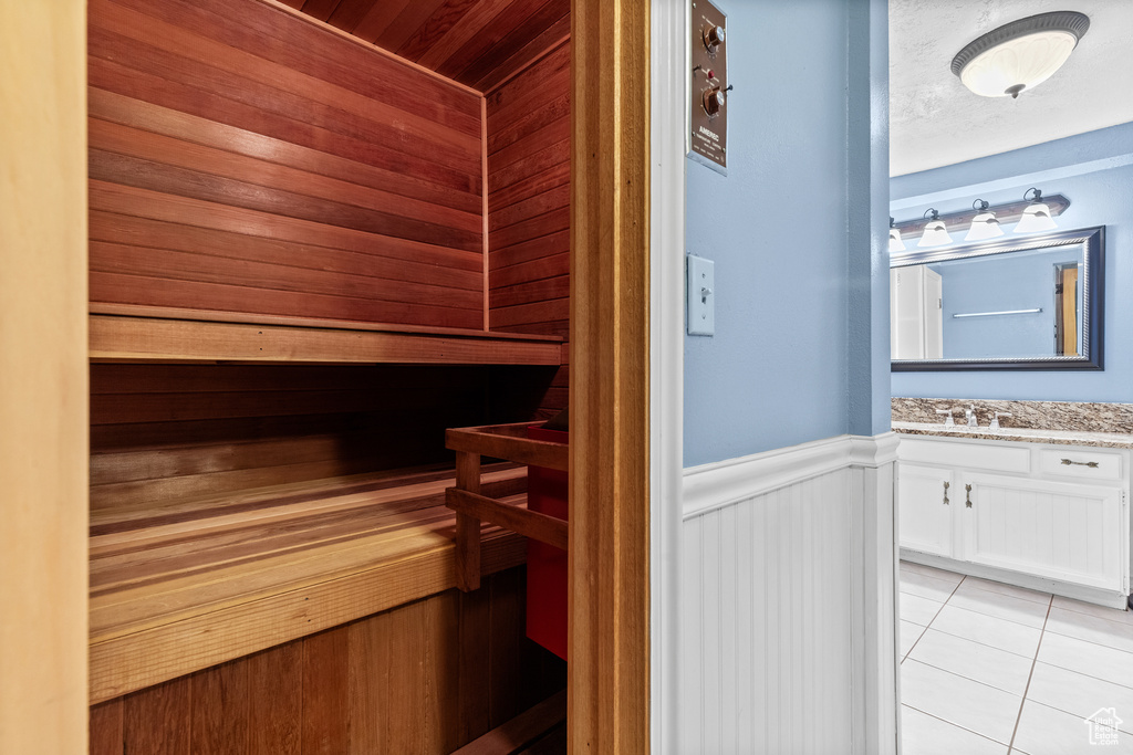Relaxing sauna / steam room with wainscoting and tile patterned flooring