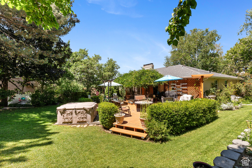 View of grassy yard featuring a wooden deck